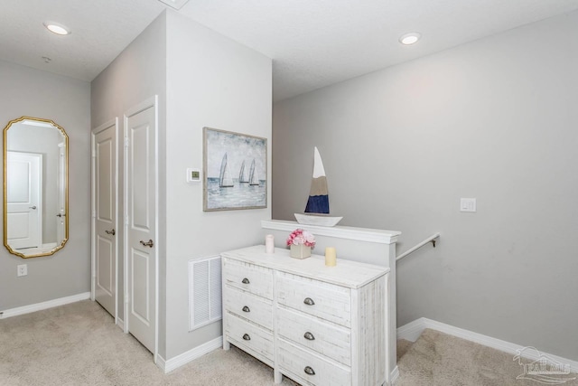 hallway with light colored carpet