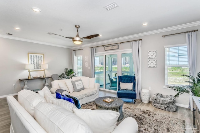 living room with ornamental molding, ceiling fan, and light hardwood / wood-style flooring