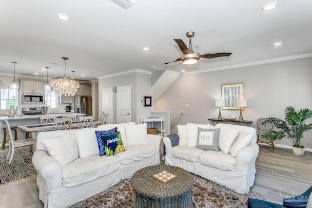 living room with ceiling fan, ornamental molding, and sink