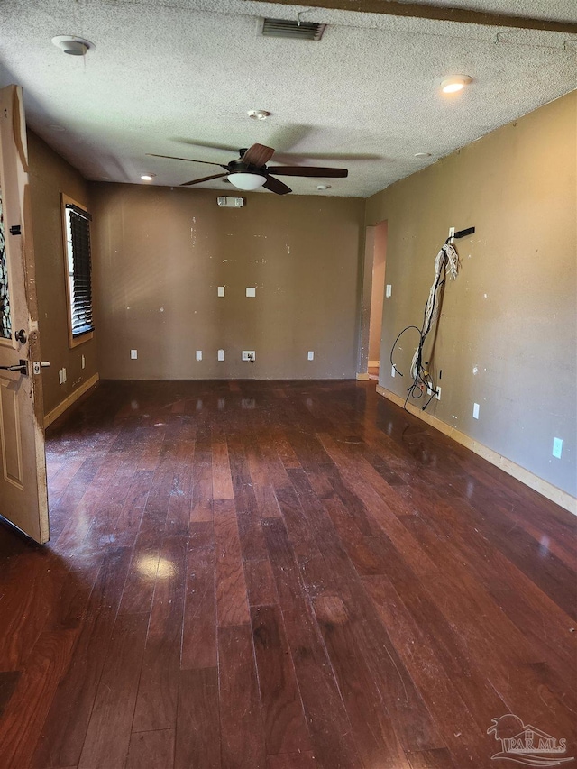 unfurnished room with a textured ceiling, dark hardwood / wood-style flooring, and ceiling fan