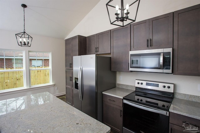 kitchen with light stone counters, a chandelier, lofted ceiling, decorative light fixtures, and appliances with stainless steel finishes