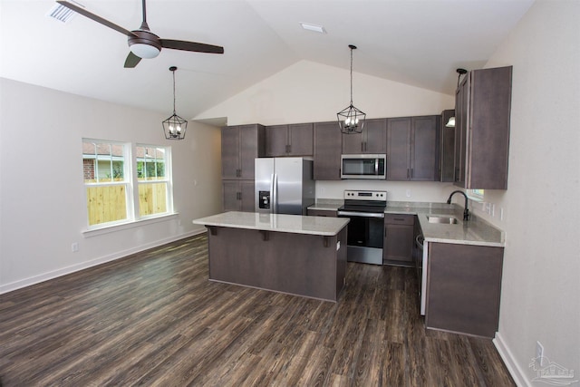 kitchen featuring sink, decorative light fixtures, vaulted ceiling, and appliances with stainless steel finishes