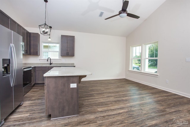 kitchen with a wealth of natural light, a kitchen island, dark wood-type flooring, and appliances with stainless steel finishes