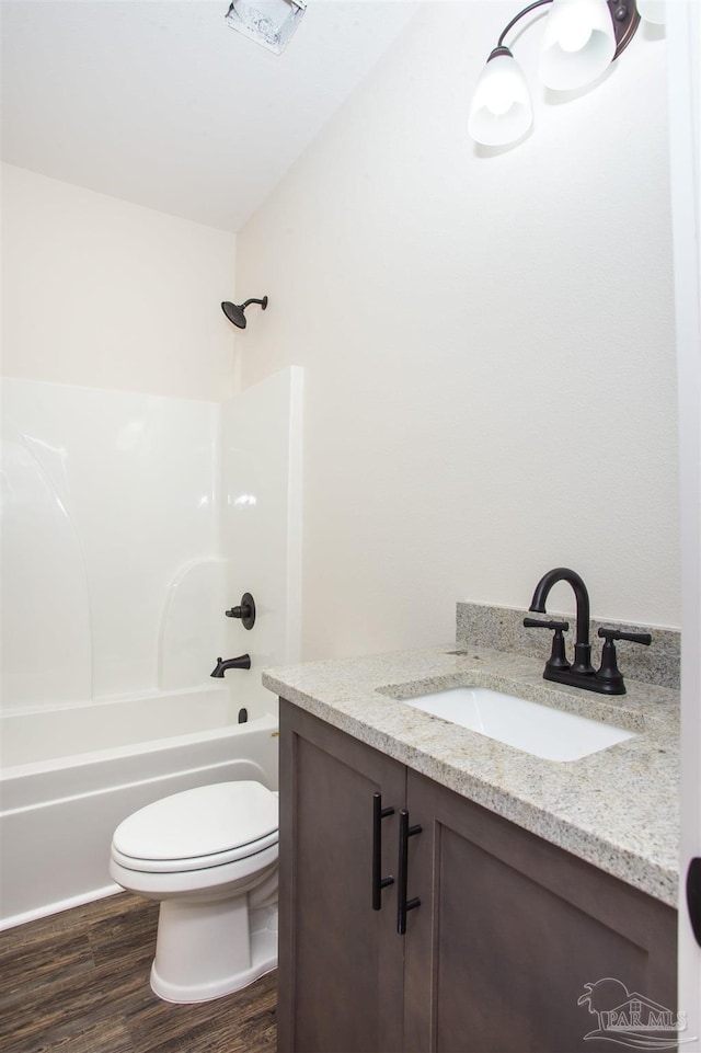 full bathroom featuring hardwood / wood-style floors, vanity, toilet, and shower / bath combination