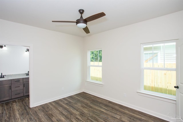 empty room with ceiling fan, sink, and dark wood-type flooring