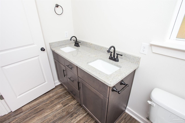 bathroom with vanity, toilet, and wood-type flooring