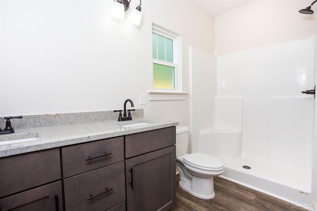 bathroom with vanity, toilet, wood-type flooring, and walk in shower