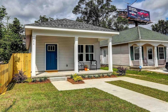 bungalow featuring covered porch and a front yard