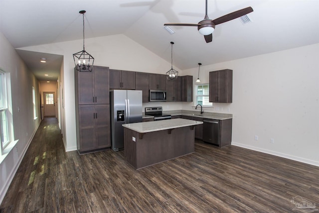 kitchen featuring sink, dark wood-type flooring, stainless steel appliances, vaulted ceiling, and a kitchen island