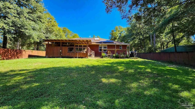 back of property featuring a lawn and solar panels