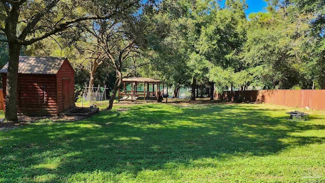 view of yard featuring a fire pit, a gazebo, and a storage unit