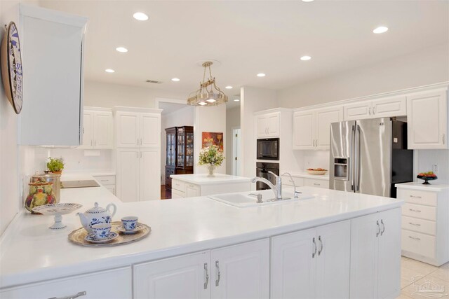 kitchen featuring white cabinets, hanging light fixtures, a center island, light tile patterned floors, and black appliances