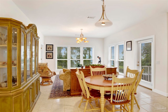 tiled dining area featuring a chandelier