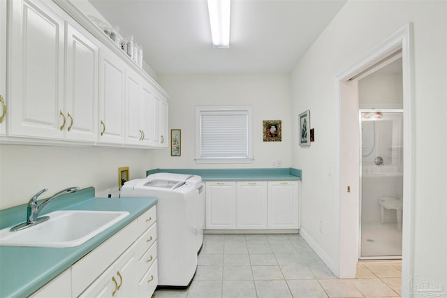 laundry area with cabinets, sink, light tile patterned floors, and independent washer and dryer