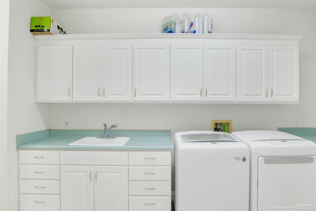 laundry area with cabinets, separate washer and dryer, and sink