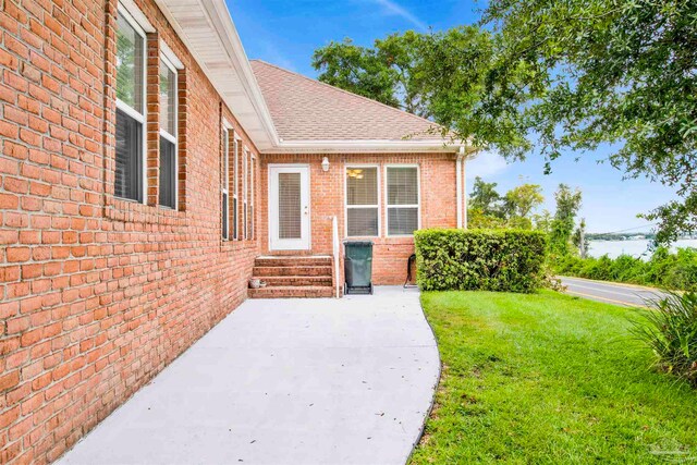 doorway to property with a yard and a patio area