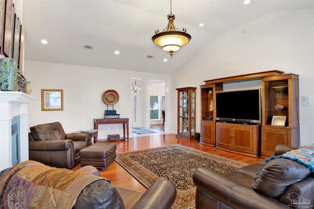 living room featuring lofted ceiling and light wood-type flooring