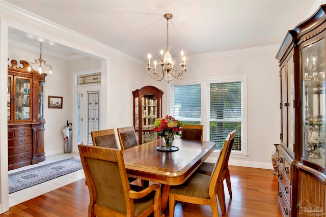 dining space featuring an inviting chandelier, crown molding, and light wood-type flooring