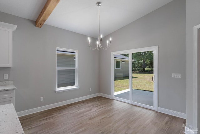 unfurnished dining area featuring an inviting chandelier, lofted ceiling with beams, and light hardwood / wood-style flooring