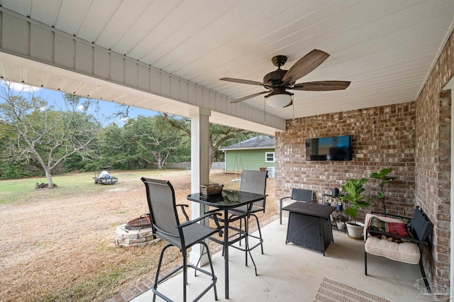 view of patio / terrace featuring ceiling fan and an outdoor fire pit