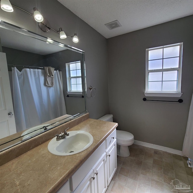 bathroom featuring a textured ceiling, toilet, and vanity