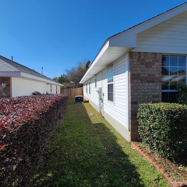 view of side of home with a yard