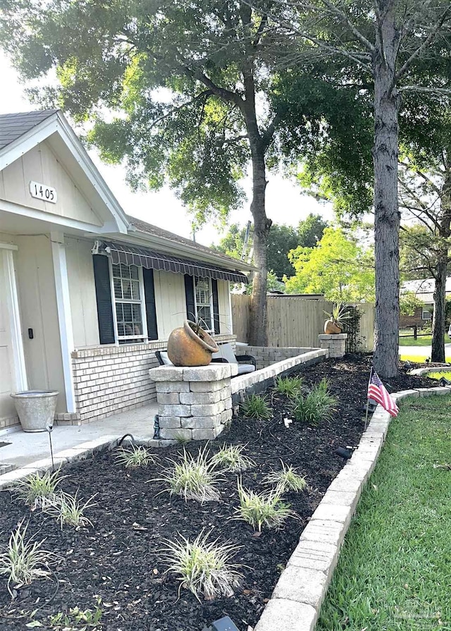 1405 College Pkwy, Gulf Breeze, FL 32563 - view of property exterior with fence, covered porch, and brick siding