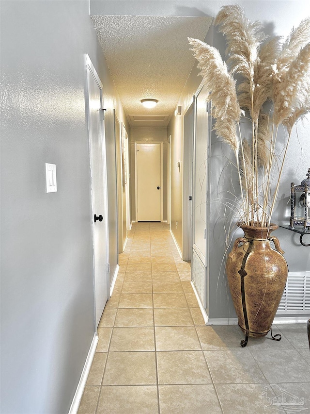 1405 College Pkwy, Gulf Breeze, FL 32563 - hall featuring baseboards, a textured ceiling, and light tile patterned floors