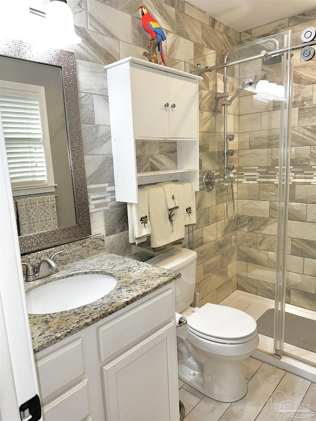 1405 College Pkwy, Gulf Breeze, FL 32563 - bathroom featuring vanity, toilet, tile walls, and a stall shower