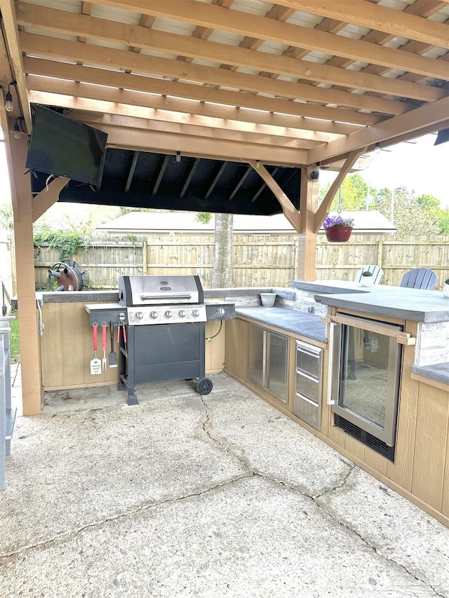1405 College Pkwy, Gulf Breeze, FL 32563 - view of patio with an outdoor kitchen, a fenced backyard, and a grill