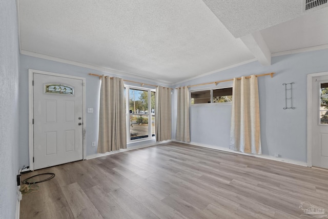 entryway with wood finished floors, baseboards, visible vents, lofted ceiling with beams, and a textured ceiling