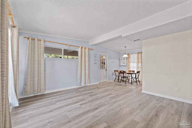 spare room featuring plenty of natural light, a textured ceiling, baseboards, and wood finished floors