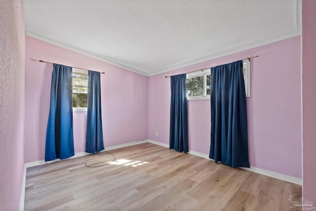 unfurnished room with baseboards, a textured ceiling, and wood finished floors