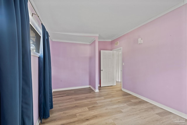 unfurnished bedroom with visible vents, baseboards, wood finished floors, and ornamental molding