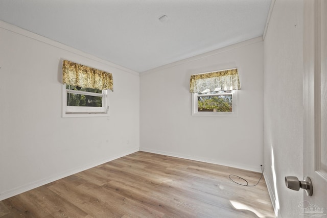 unfurnished room featuring ornamental molding, baseboards, and wood finished floors