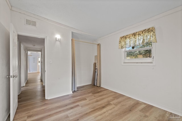 empty room with visible vents, baseboards, and light wood-style floors