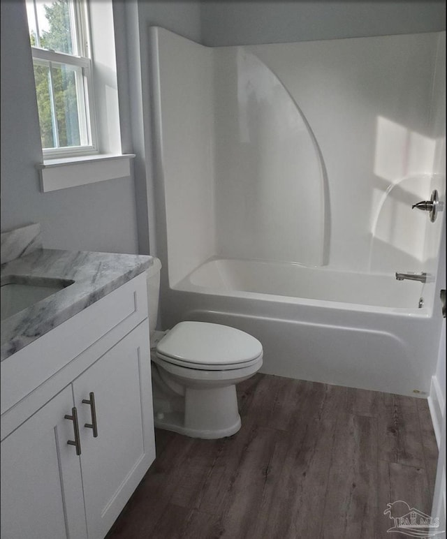 bathroom with vanity, wood finished floors, bathtub / shower combination, and toilet