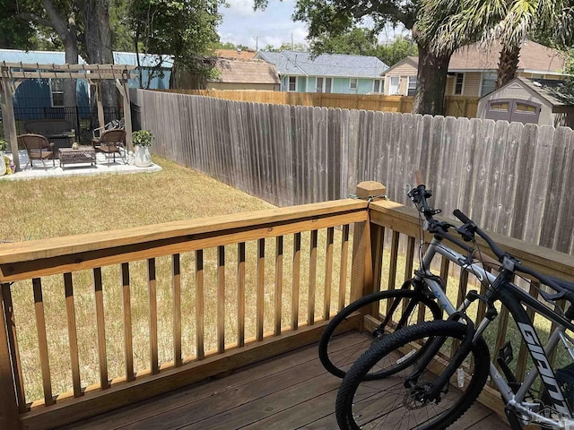 deck with a patio, a fenced backyard, and a fire pit