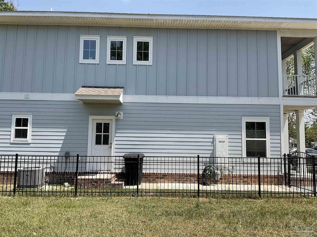 back of property with fence and board and batten siding