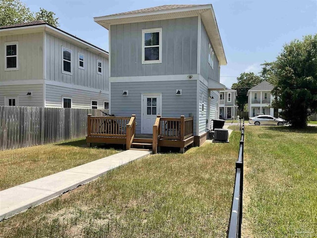 rear view of property with board and batten siding, a deck, cooling unit, and fence