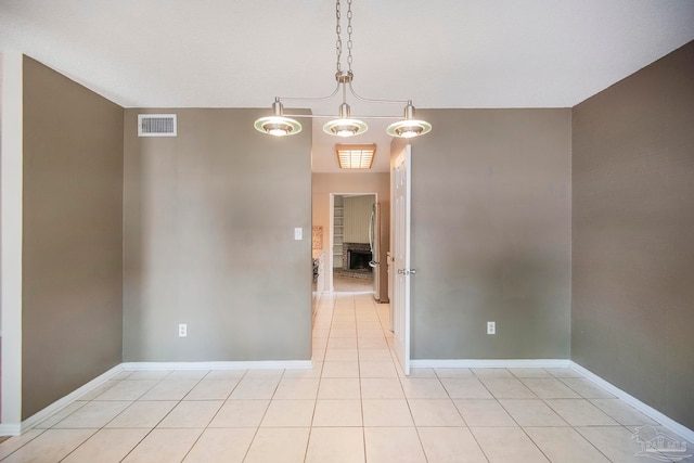 unfurnished room featuring a chandelier and light tile patterned floors