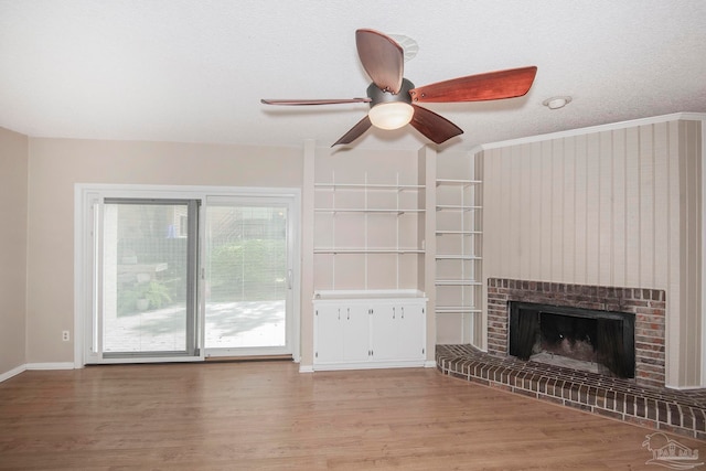 unfurnished living room with a fireplace, light hardwood / wood-style floors, a textured ceiling, ceiling fan, and ornamental molding