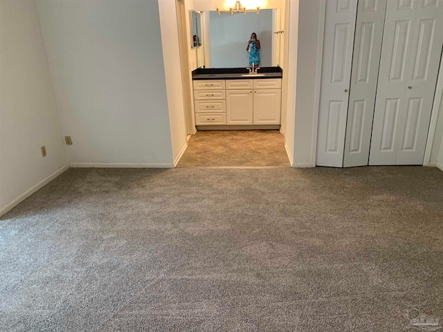 unfurnished bedroom featuring sink and light carpet