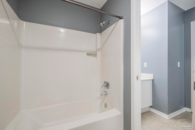 bathroom featuring vanity, washtub / shower combination, a textured ceiling, and tile patterned floors