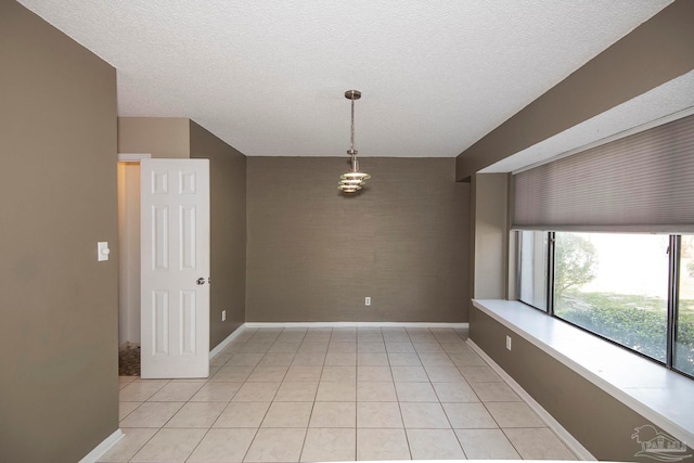 tiled empty room with a textured ceiling