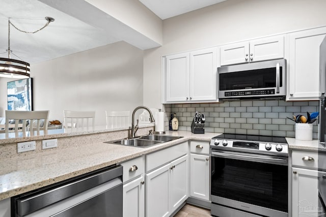 kitchen featuring tasteful backsplash, sink, light stone countertops, stainless steel appliances, and white cabinets