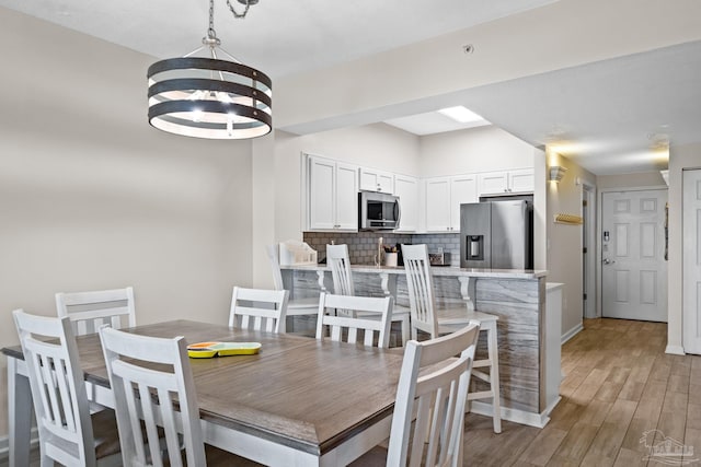 dining area with an inviting chandelier and wood-type flooring