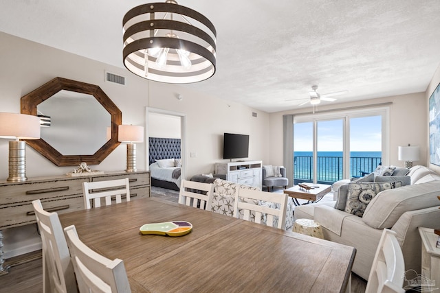 dining area featuring ceiling fan, a textured ceiling, and hardwood / wood-style flooring