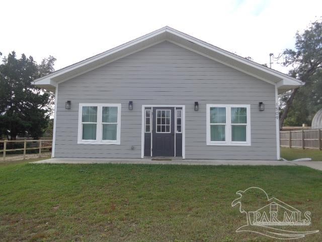 rear view of property featuring a yard