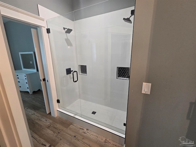 bathroom featuring wood-type flooring and a shower with shower door